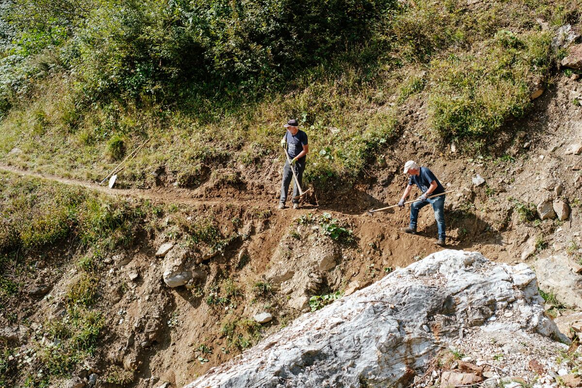 Freiwillige Helfer beim Sanieren eines Wanderweges